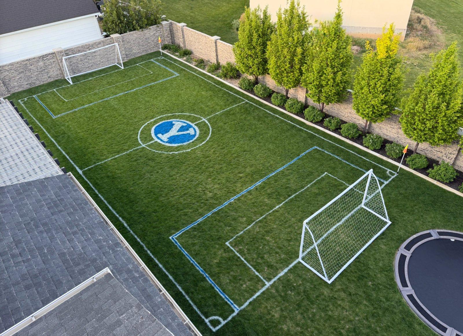 A custom-painted backyard sports field with goals set up, GAMEDAY style